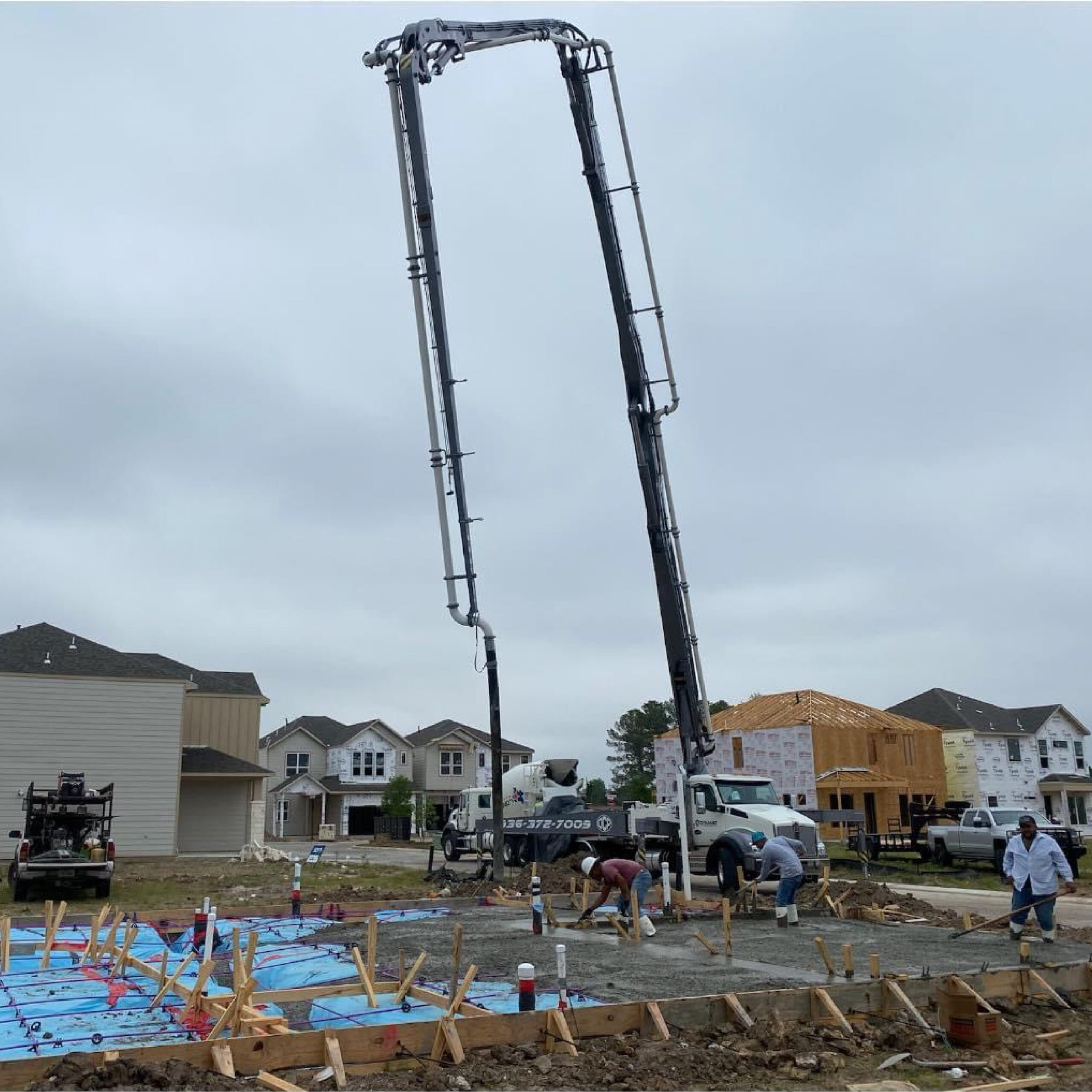 Dynamic Concrete Pumping 41-meter boom extended over a residential foundation pour